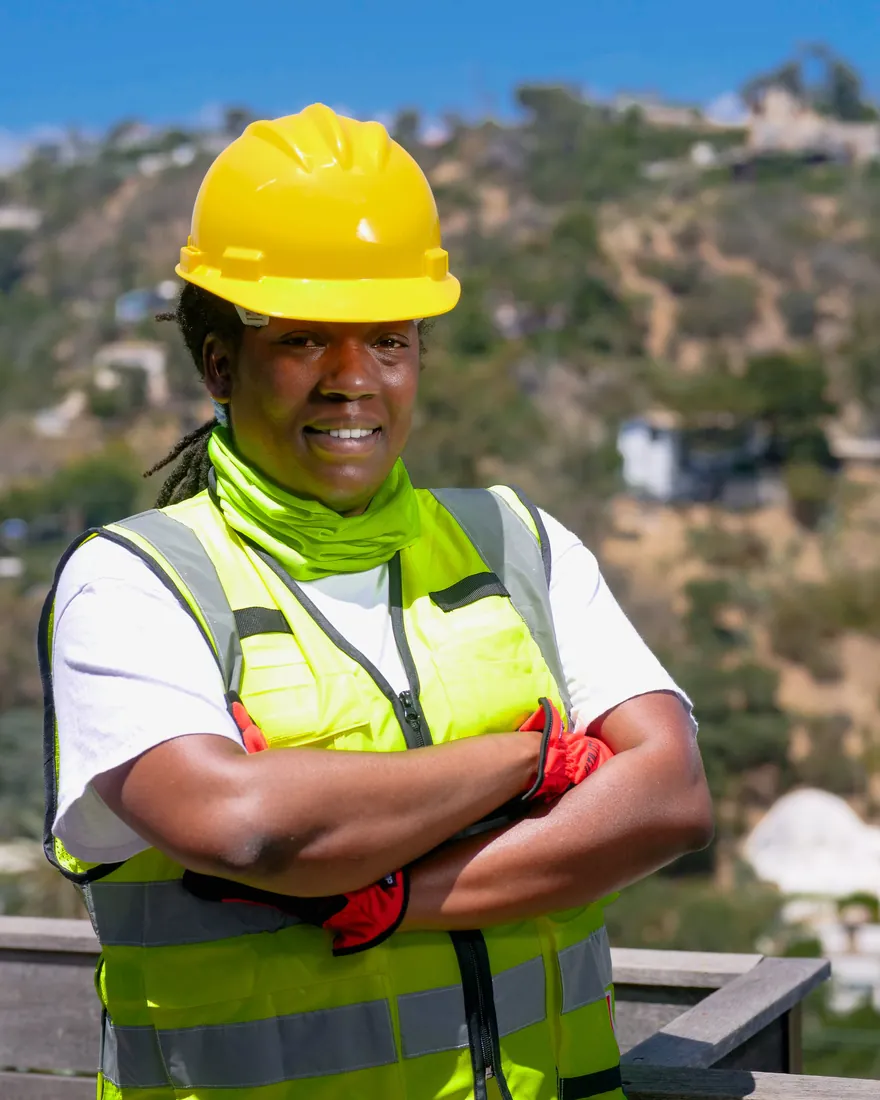 Tradesperson in a hard hat smiling on a jobsite